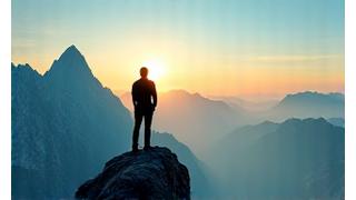 Person standing confidently overlooking a vast landscape, symbolizing strength and self-assurance.
